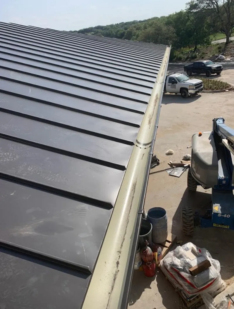 Standing seam panel and gutter detail on a metal roofing jobsite in Thomas
